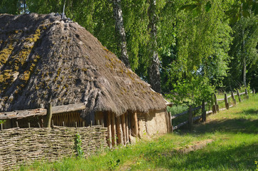 An old sloping clay house with a straw roof