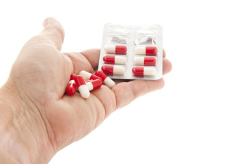 Capsules in red and white in hand