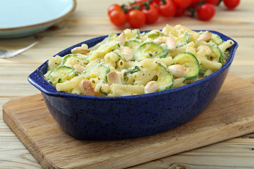 pasta gratinata maccheroni al forno con zucchini mandorle e formaggio su sfondo tavolo di cucina