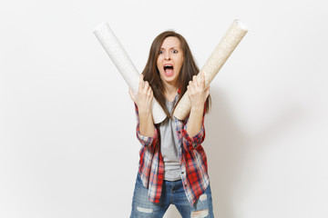 Irritated woman in casual clothes holding wallpaper rolls and screaming isolated on white...