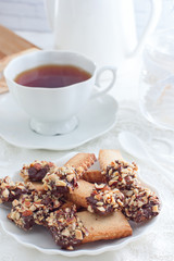 Cookies with nuts and chocolate and a cup of tea, selective focus