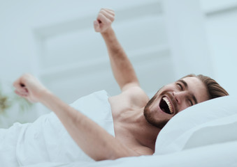happy man waking up in a comfortable room