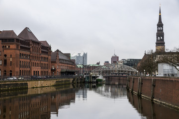 Naklejka premium Hamburg, Germany. Panorama of the city, with the Warehouse District, the Elbphilharmonie, the Zollkanal, Kornhausbrucke bridge and St. Catherine's Church (Sankt Katharinen)