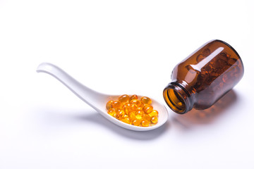 A spoon of the cod liver oil with a bottle