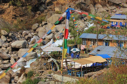 Huts and prayer flags in Bamboo, small settlement in the Langtang National Park. River Langtang Khola.
