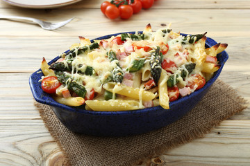 pasta gratinata maccheroni al forno con verdure e legumi vari su sfondo tavolo di cucina