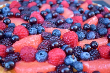 Close up Fruits Berry Fresh Raspberry Blueberry Grapefruit Summer Berries. Homebaked Tart. Homemade Cake. Top view. Wooden Rustic Background