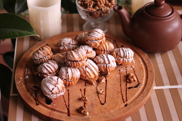 Cookie slide on a wooden Board with a kettle and nuts