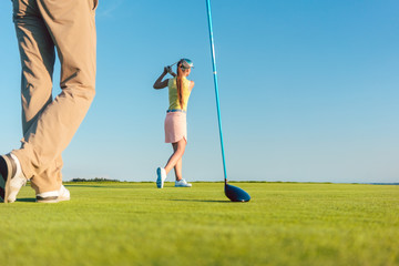Low-angle full length view of a female professional golfer hitting a long shot, during a...