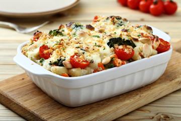 pasta gratinata maccheroni al forno con verdure e legumi vari su sfondo tavolo di cucina