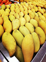 Fresh yellow manggoes display in the market stall.