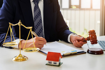 Home and land lawsuit concept, Lawyers hold a gavel to judge law and land to client.