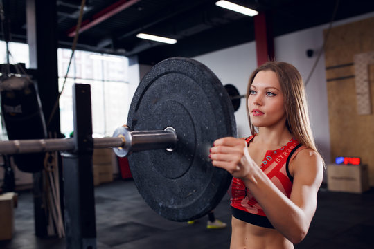 Picture of athlete girl in sports clothes with barbell