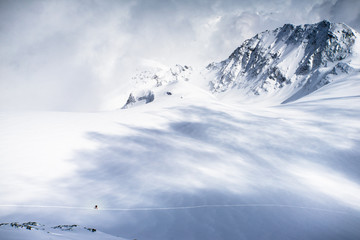 A lone skier exploring the snow fields and high mountains of the Swiss Alps