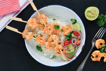 Tandoori prawn skewers with rice and chopped salad - top view