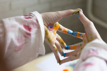 Photo of female hands smeared with colorful paint