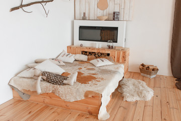 Modern hunting house bedroom interior with fireplace and animal skin on bed