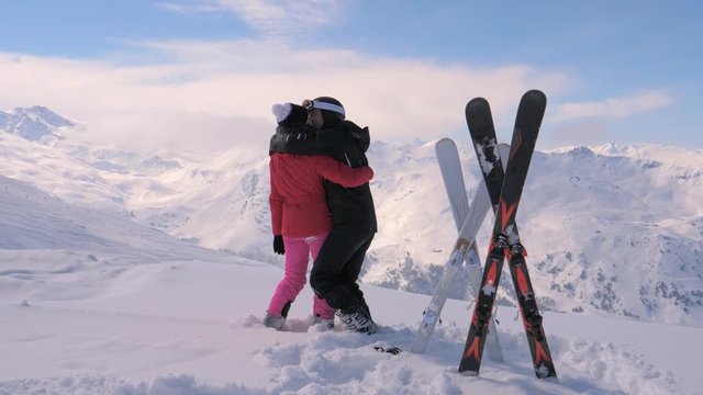 Couple Skiers In Love Kisses and Hugs on the Top of the Mountain