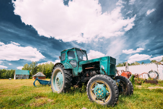 Old Tractor Parking In Backyard In Summer Sunny Day. Special Agricultural Equipment.