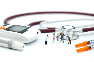 Miniature people: doctor and Family standing with stethoscope and syringe and glucose meter, lancet using as background health care Medical, Check up, Medicine, diabetes, hypoglycemia concept.