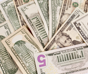 Pile of various US american dollar money bills spread on white background.
