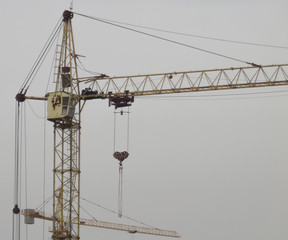 Construction cranes against the gray sky. Industrial constrcution cranes. Abstract background with...