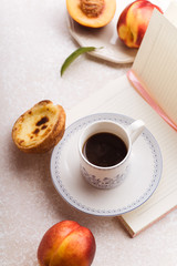 Flatlay image of female workspace with notepad, cup of coffee and fruit snacks in blush pink color setting