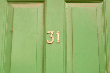 House number 31 sign on door painted green