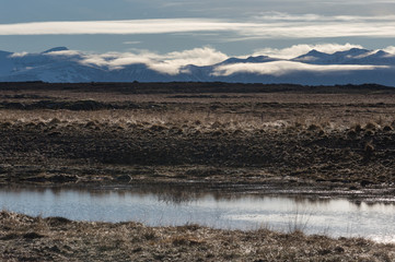 Fototapeta na wymiar Islanda, la terra dei vichinghi, Paesaggio con montagne, nuvole e fiume.