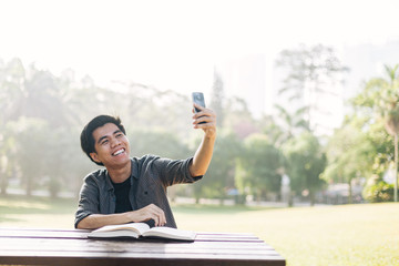 Young man taking selfie at a park