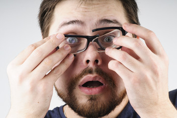 Shocked man with broken glasses on his face - 200219423