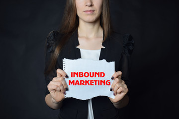 Fototapeta na wymiar In the hands of a businessman a scrap of paper with the inscription:INBOUND MARKETING