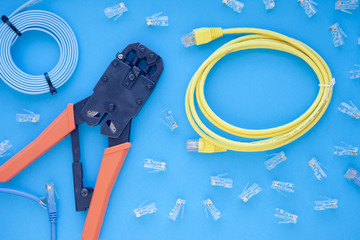 SKS and engineering concept. Set of connectors, ethernet and console cables, crimp tool on the blue...