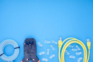 SKS and engineering concept. Set of connectors, ethernet and console cables, crimp tool on the blue...