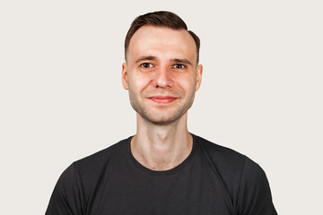 Obraz premium Funny young smiling guy on gray background.