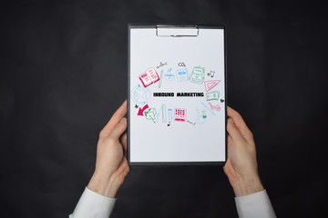 In the hands of a businessman a notebook with the inscription:INBOUND MARKETING