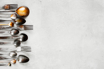 Background with vintage silverware on the grey table