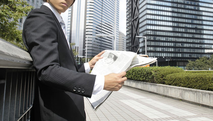 新聞を読む若いビジネスマン