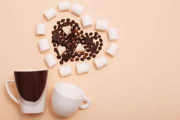 two cups  with coffee beans in in the shape of a heart