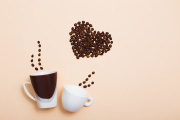 two cups  with coffee beans in in the shape of a heart