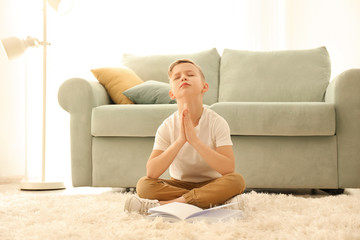 Fototapeta na wymiar Religious little boy praying at home