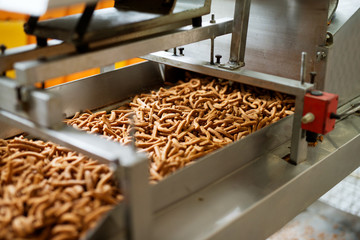Close up picture of a salt sticks being pushed trough factory production line toward their next processing.