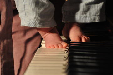 Musician and child's feet of kid in hands of mother
