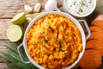 Delicious puree of sweet potato with garlic and onion close-up in a bowl. horizontal top view