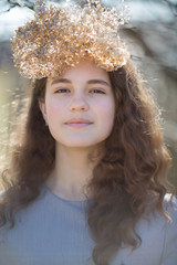Portrait of a young caucasian woman. Happy beautiful curly girl close-up, wind fluttering hair. Spring portrait outdoors.