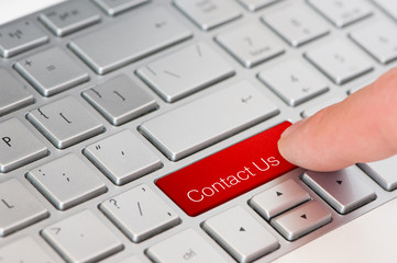 a finger press red Contact us button on laptop keyboard