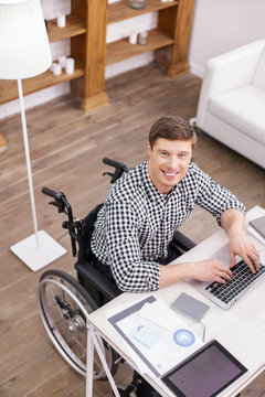 Love my job. Cheerful male person raising head while staring at camera