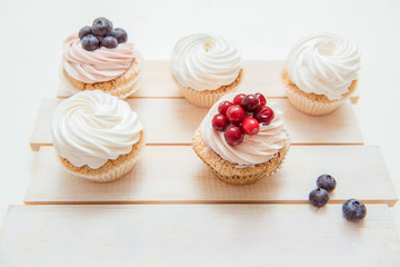 Delicious cupcakes with white whipped cream and berries
