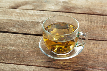 cup of black tea with mint leaves on a wooden table