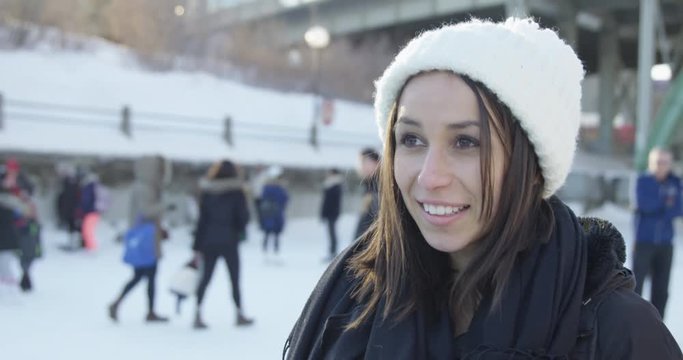 Young woman on rideau canal during winter festival - looking up and down happily